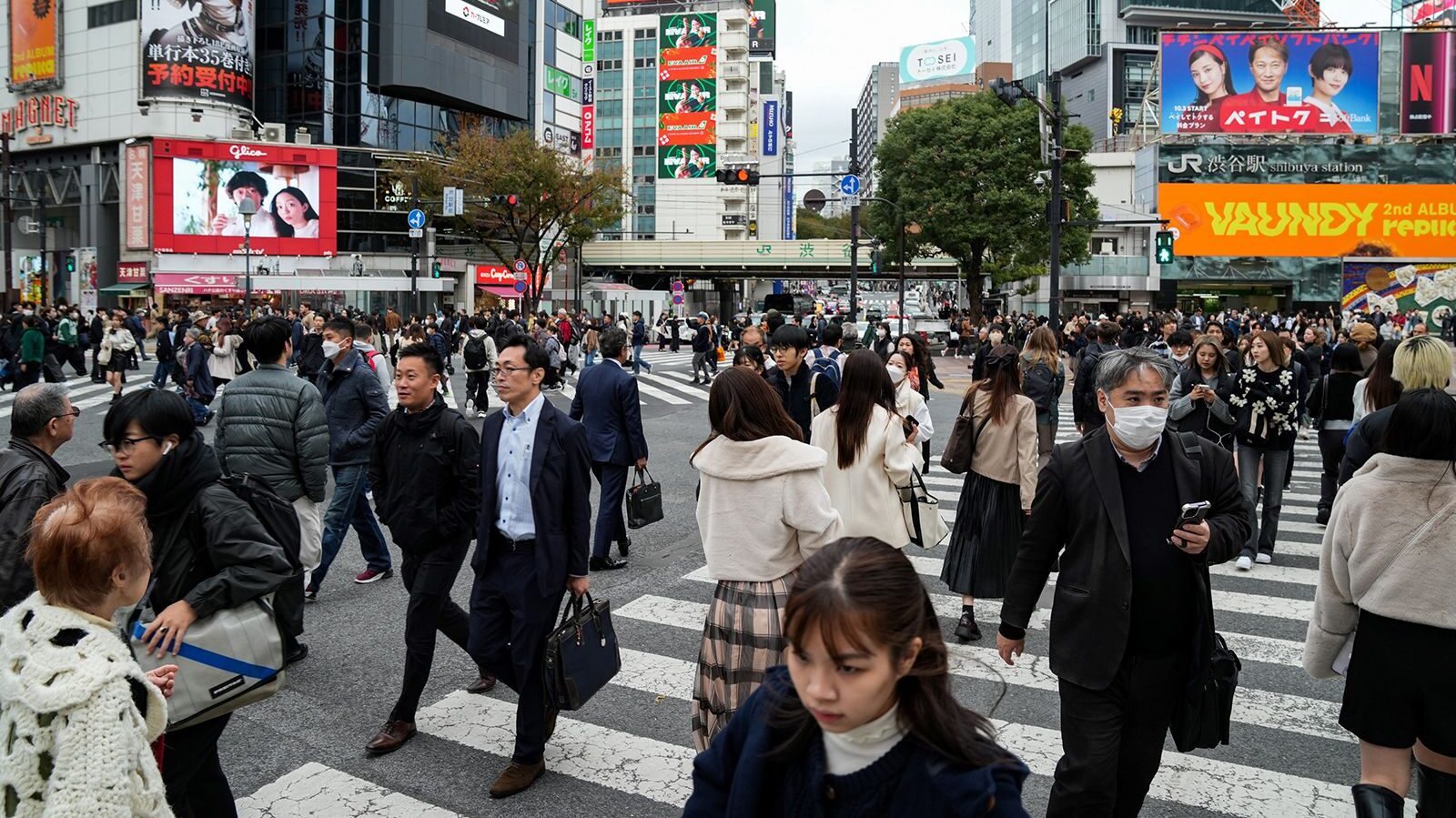 People walk past a busy crossing in Tokyo, Japan on November 15, 2023....