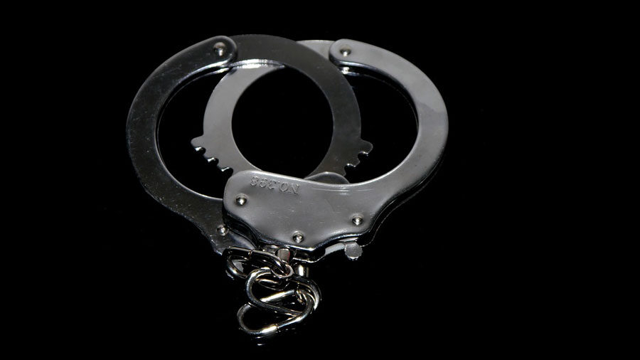 Handcuffs are shown against a black background....