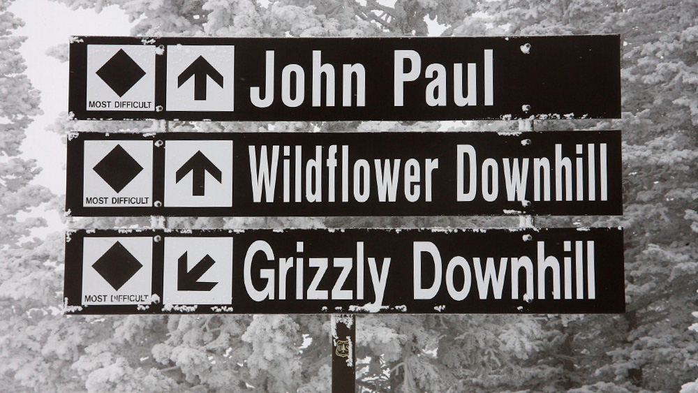 Difficult terrain signs read "John Paul," "Wildflower Downhill," and "Grizzly Downhill," directing ...
