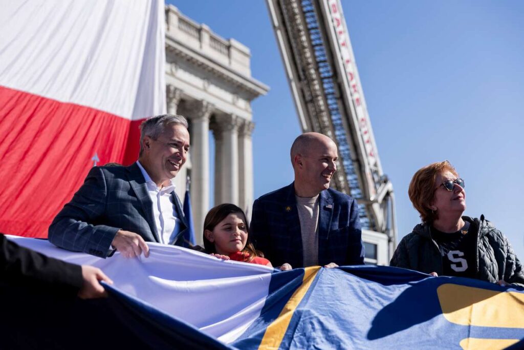 Gov. Spencer Cox and Sen. Daniel McCay, R-Riverton, help to raise Utah’s new state flag during the commemoration of Utah Flag Day at the state Capitol in Salt Lake City on Saturday.