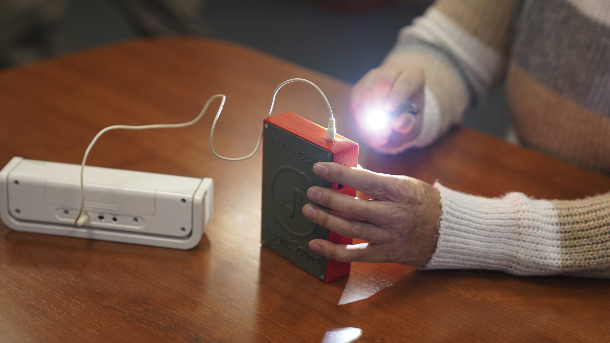 Minh Ha, assistive technology manager at the Perkins School for the Blind uses a flashlight to try ...