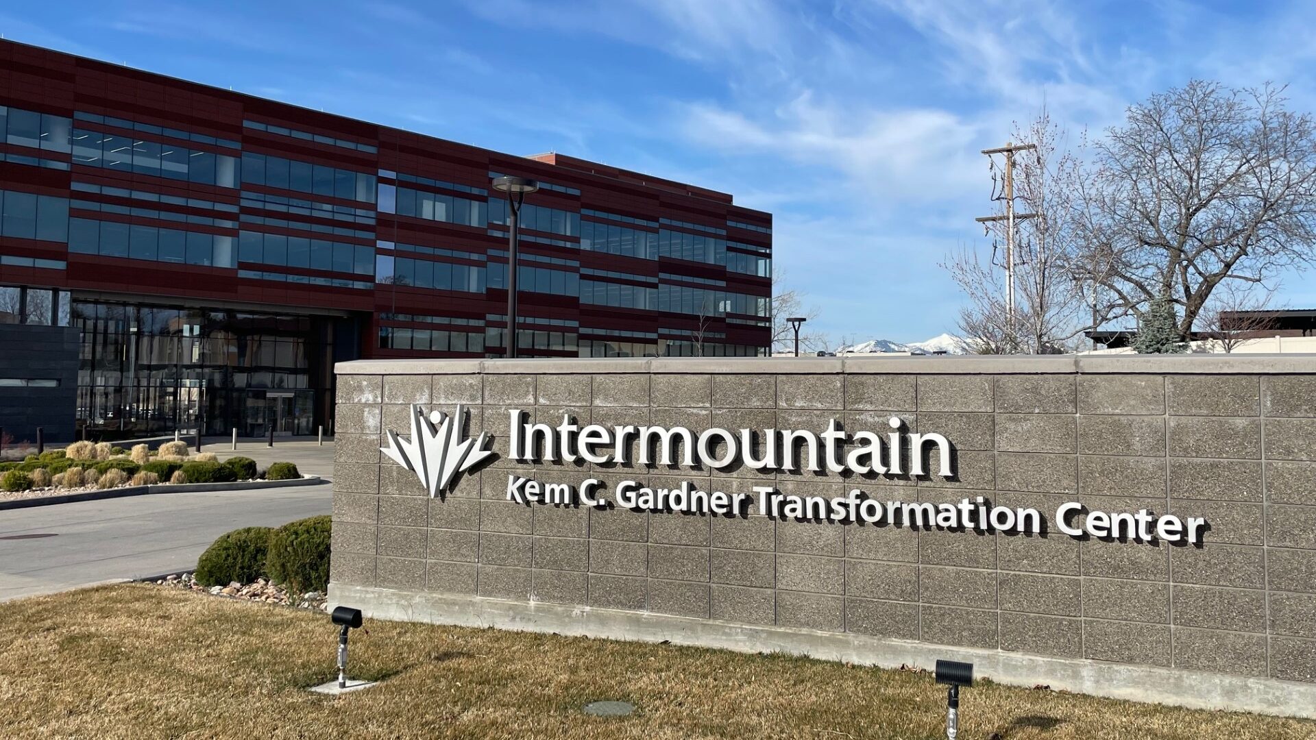 A sign for Intermountain Health's Kem. C Gardner Transformation Center outside the building...
