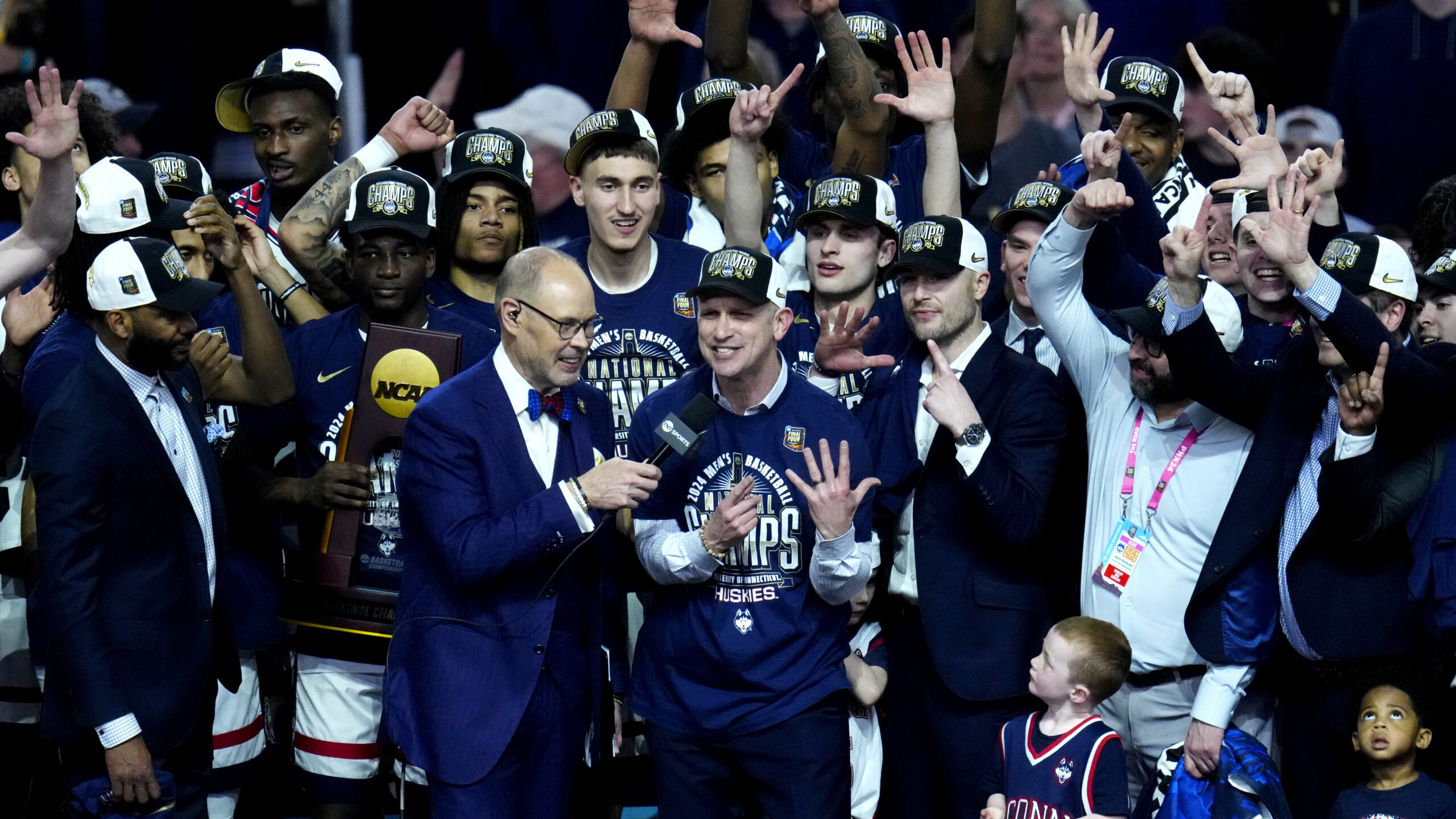 UConn head coach Dan Hurley, center, and his players celebrate after the NCAA college Final Four ch...