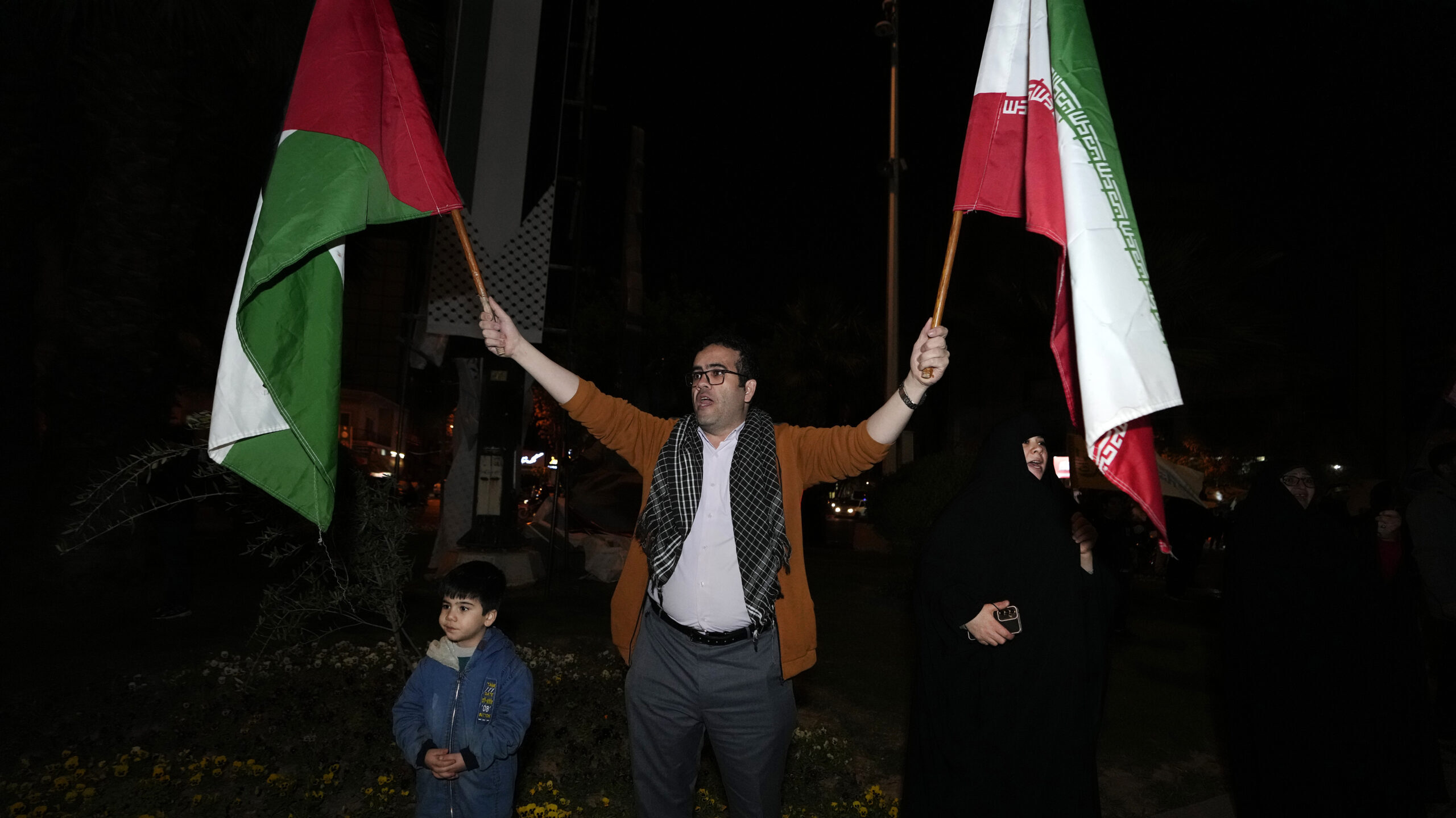 A demonstrator waves Iranian and Palestinian flags during an anti-Israeli gathering at the Felestin...