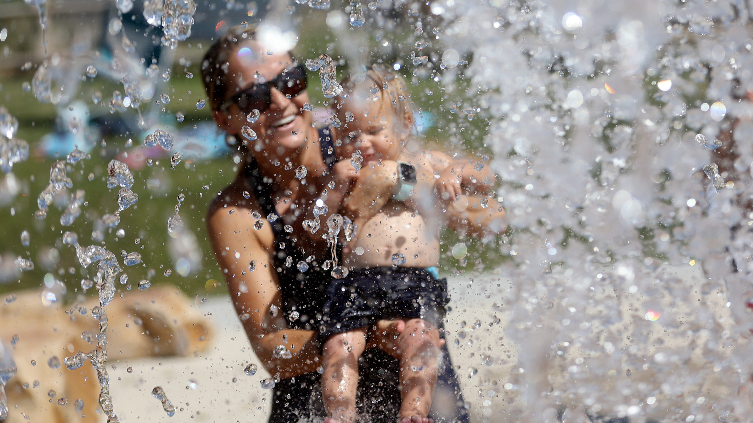 FILE: Joana Abeel holds her daughter, Penelope Abeel, at the Draper City Splash Pad during a heat w...