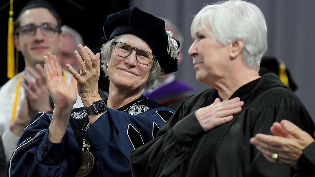 President Elizabeth "Betsy" Cantwell, left, applauds after Gail Miller gave the commencement addres...