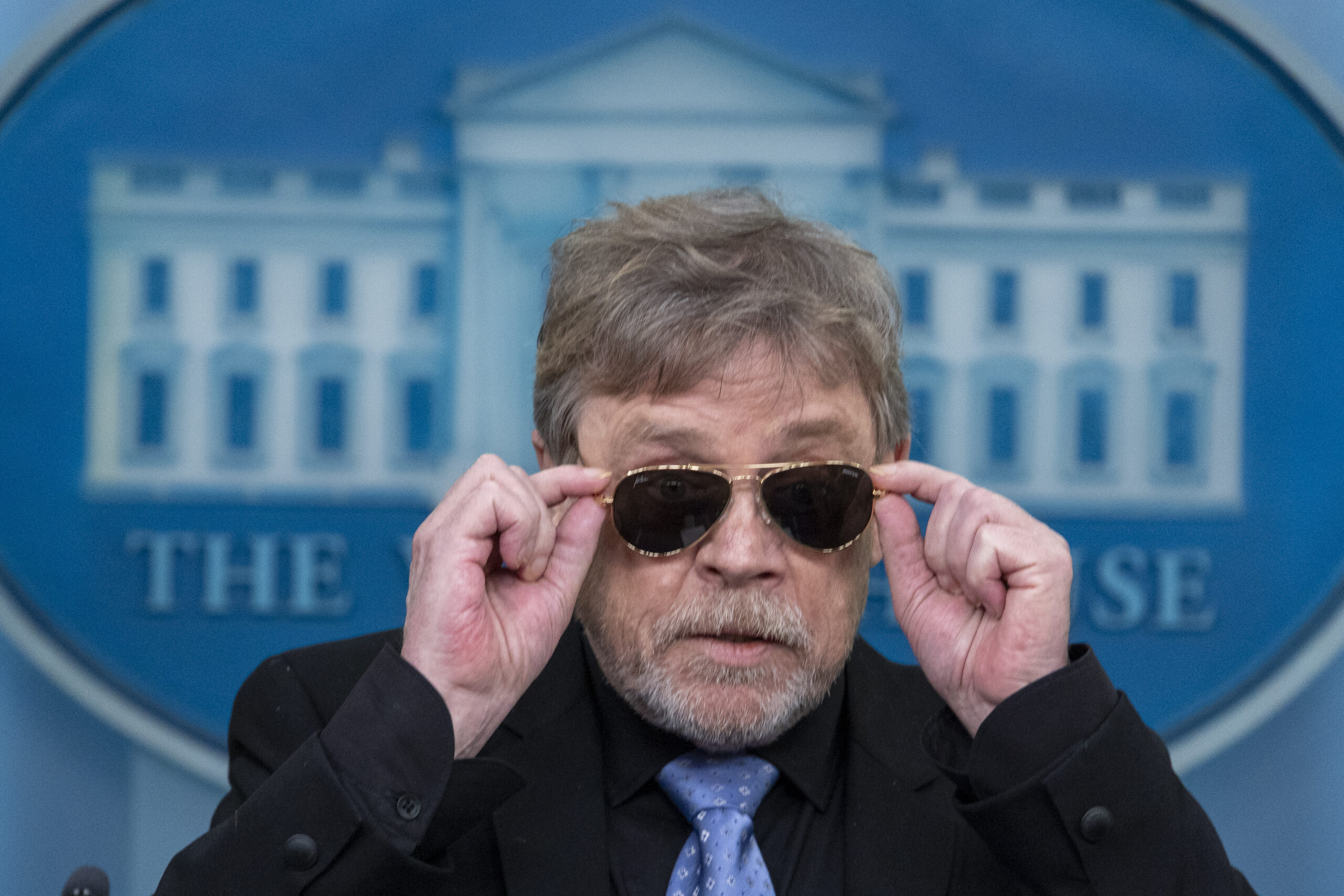 Actor Mark Hamill takes off sunglasses given to him by President Joe Biden, as he joins White House...