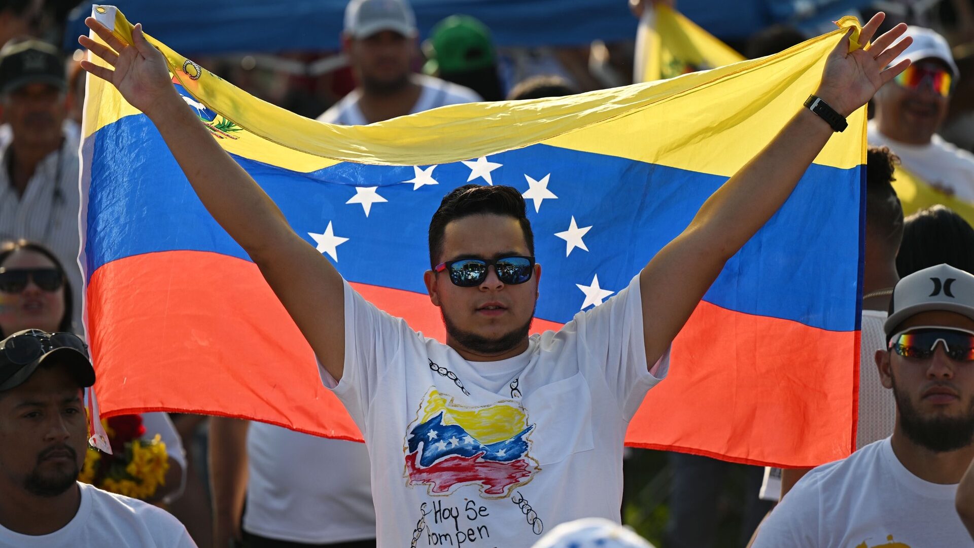 Man with flag celebrates alongside other Venezuelans elections in Herriman City. July 28, 2024 (Sco...