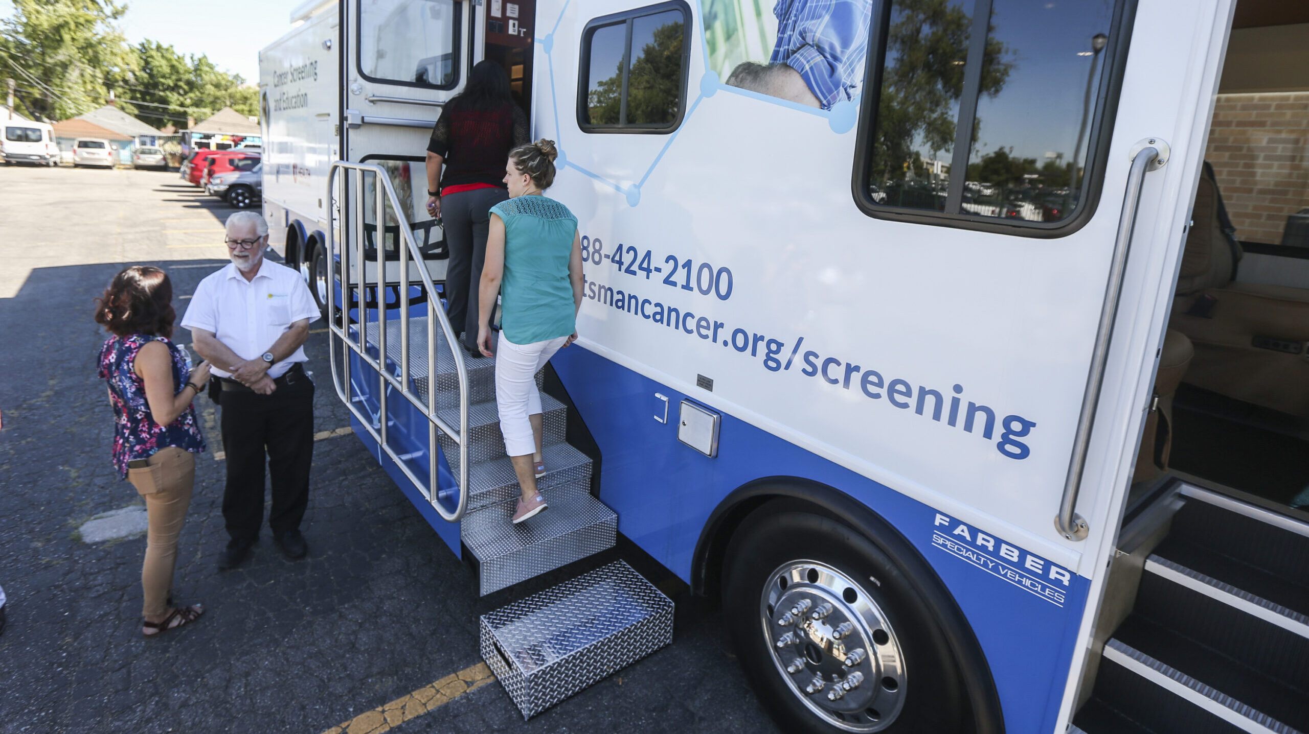 People climb a set of stairs to tour he Huntsman Cancer Institute's new cancer screening bus at the...