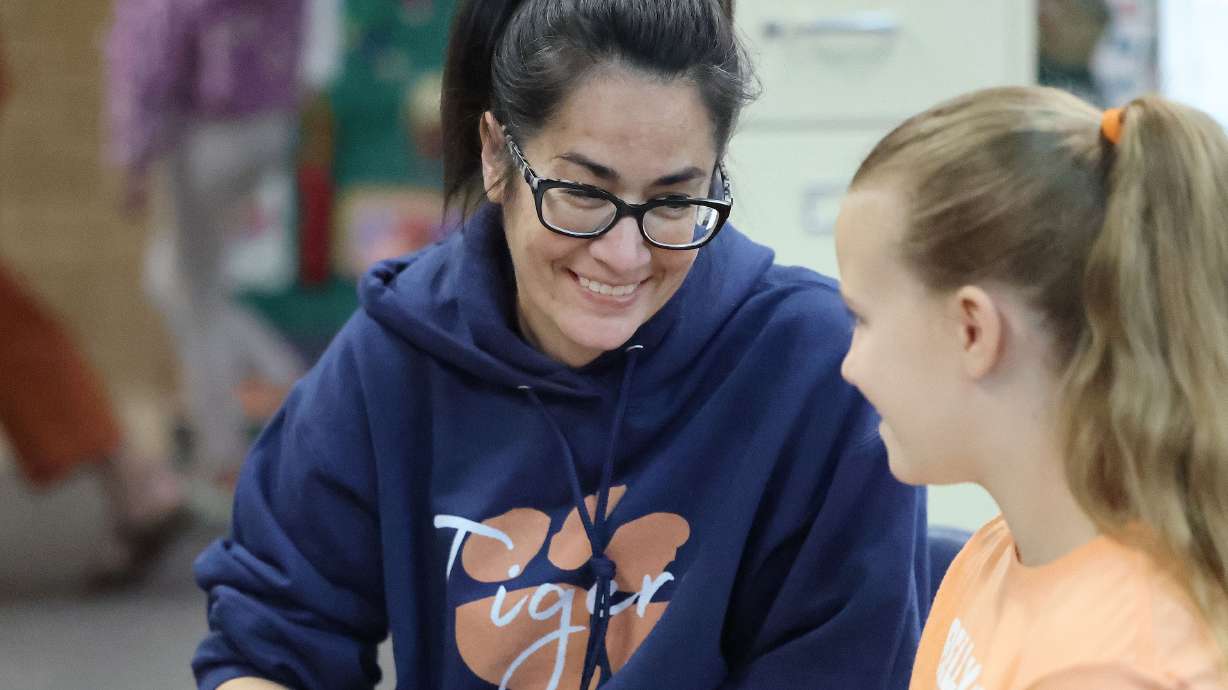 Bella Vista elementary parent volunteer Alisha Betenson reads with third-grader Sadie Tucker in Cot...