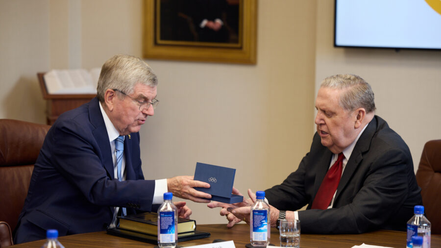 Thomas Bach, president of the IOC, presents a gift to Acting President Jeffery R. Holland of the Qu...