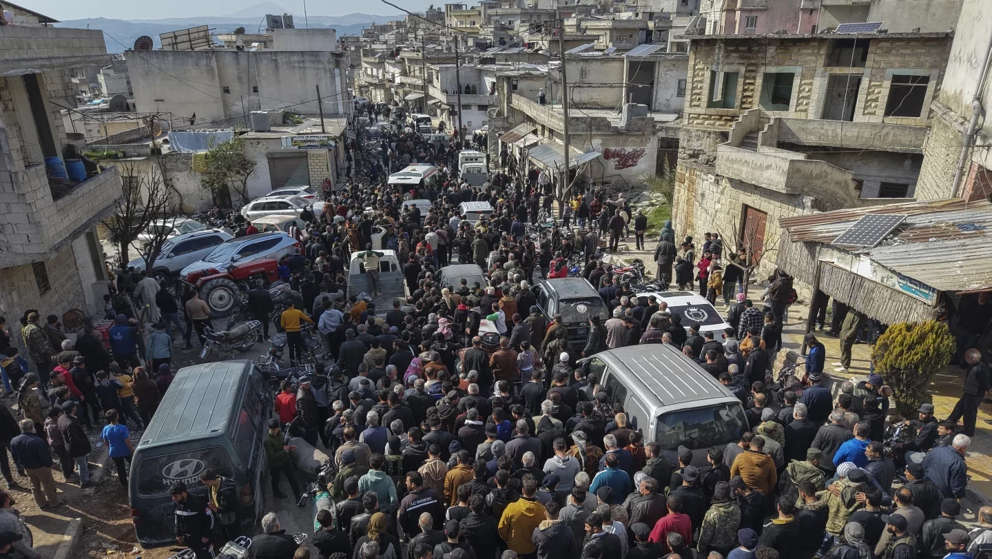 Relatives and neighbors attend the funeral procession for four Syrian security force members killed...