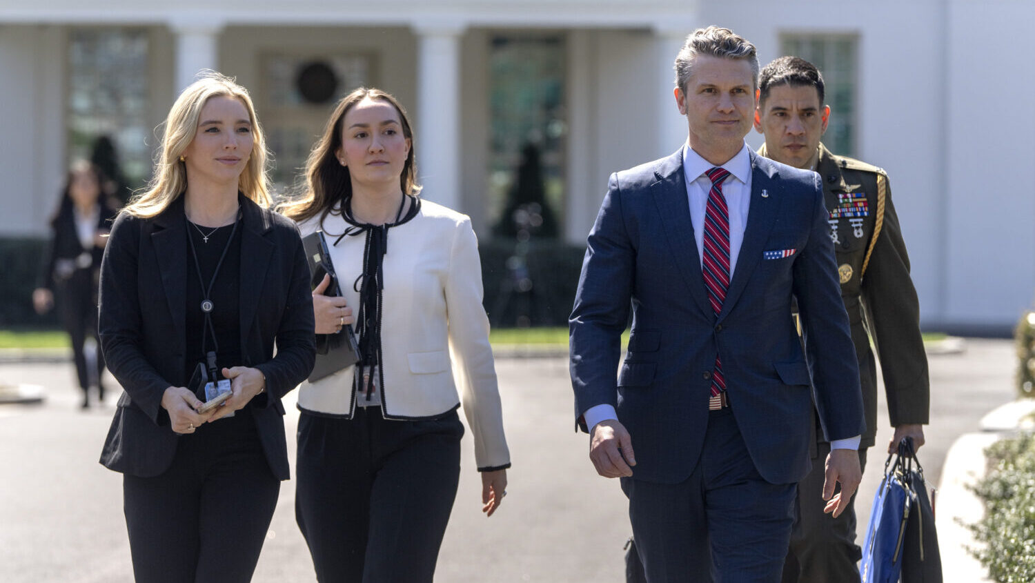 Defense Secretary Pete Hegseth, second from right, walks outside the Oval Office at the White House...