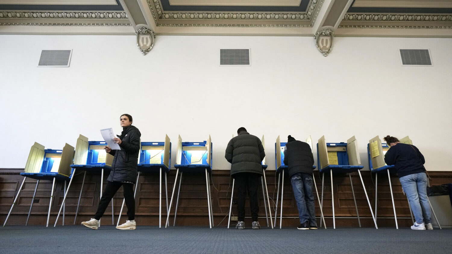 Voters mark their ballots while voting at Centennial Hall at the Milwaukee Central Library on Elect...