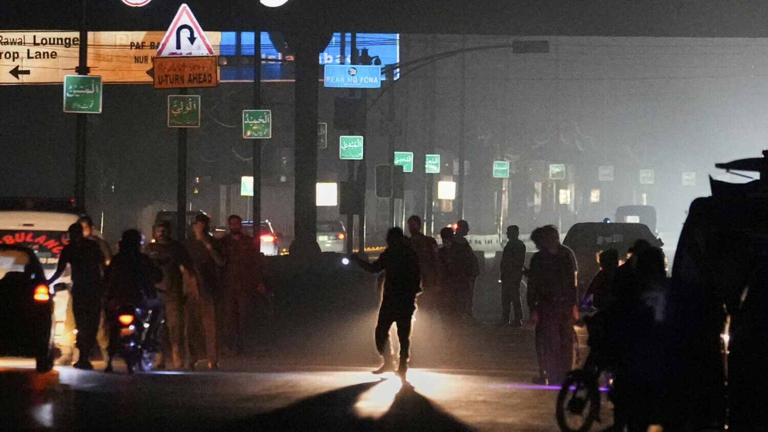 Police officers remove vehicles and people from the main entry of Nur Khan airbase following Indian...