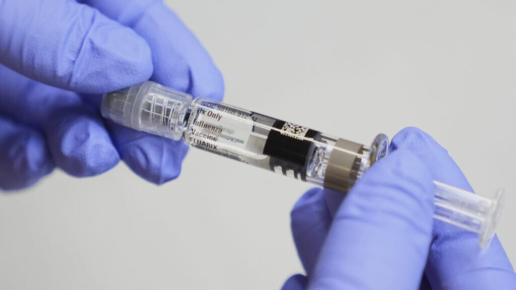 Clinic support supervisor May Fengmei Lin, CMA, displays a syringe of the Fluarix flu vaccine at In...