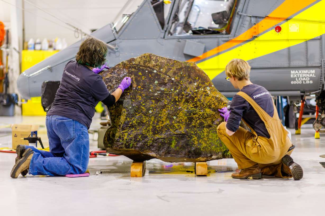 Conservators from the Midwest Art Conservation Center carefully clean and preserve this lichen-covered petroglyph on Dec. 9, in Provo.