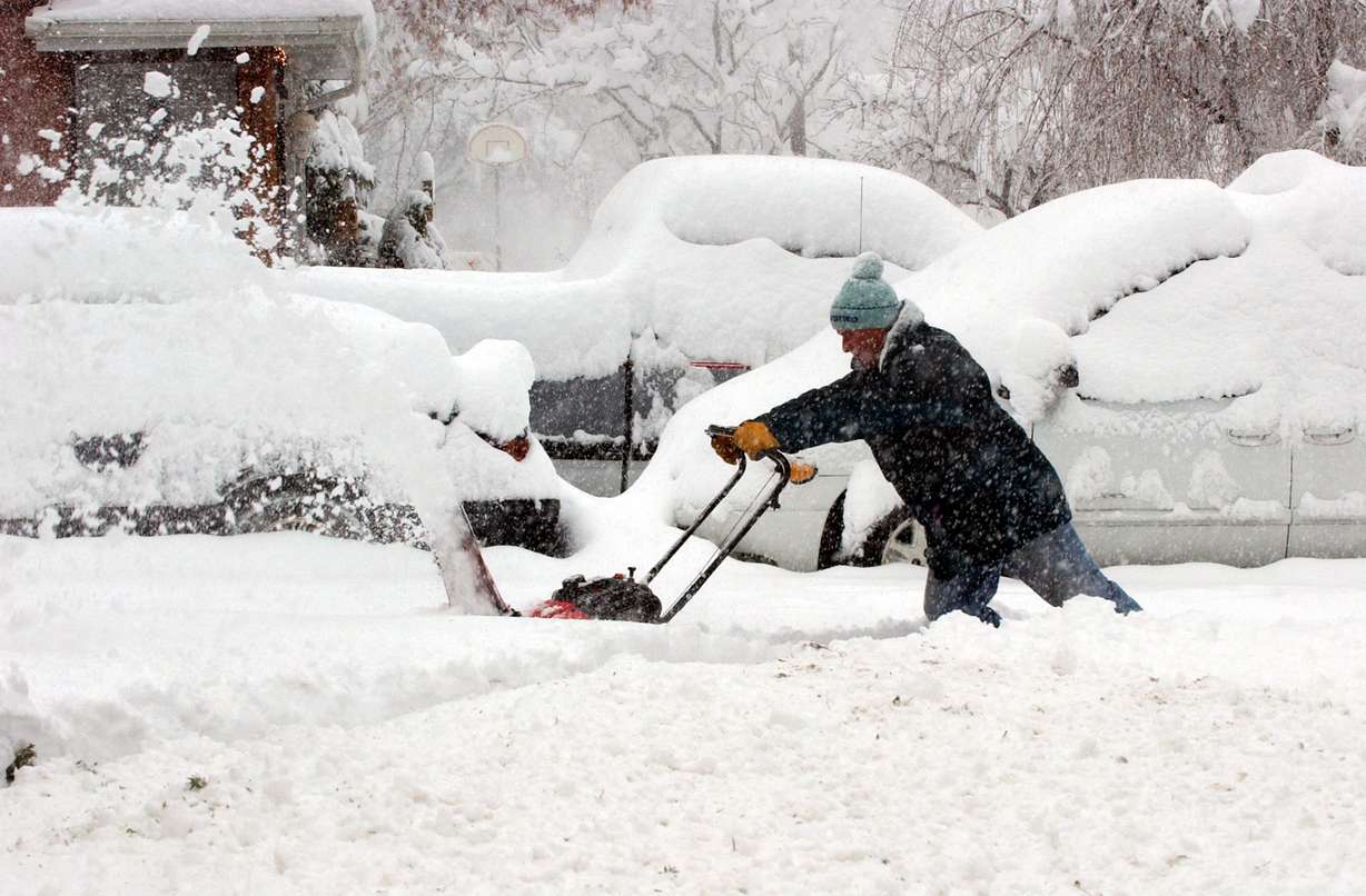 Tom Smith uses his snowblower to clear his neighbor’s driveway on Evergreen Avenue in Salt Lake City during a snowstorm on Dec. 26, 2003. (Photo: Ravell Call, Deseret News)