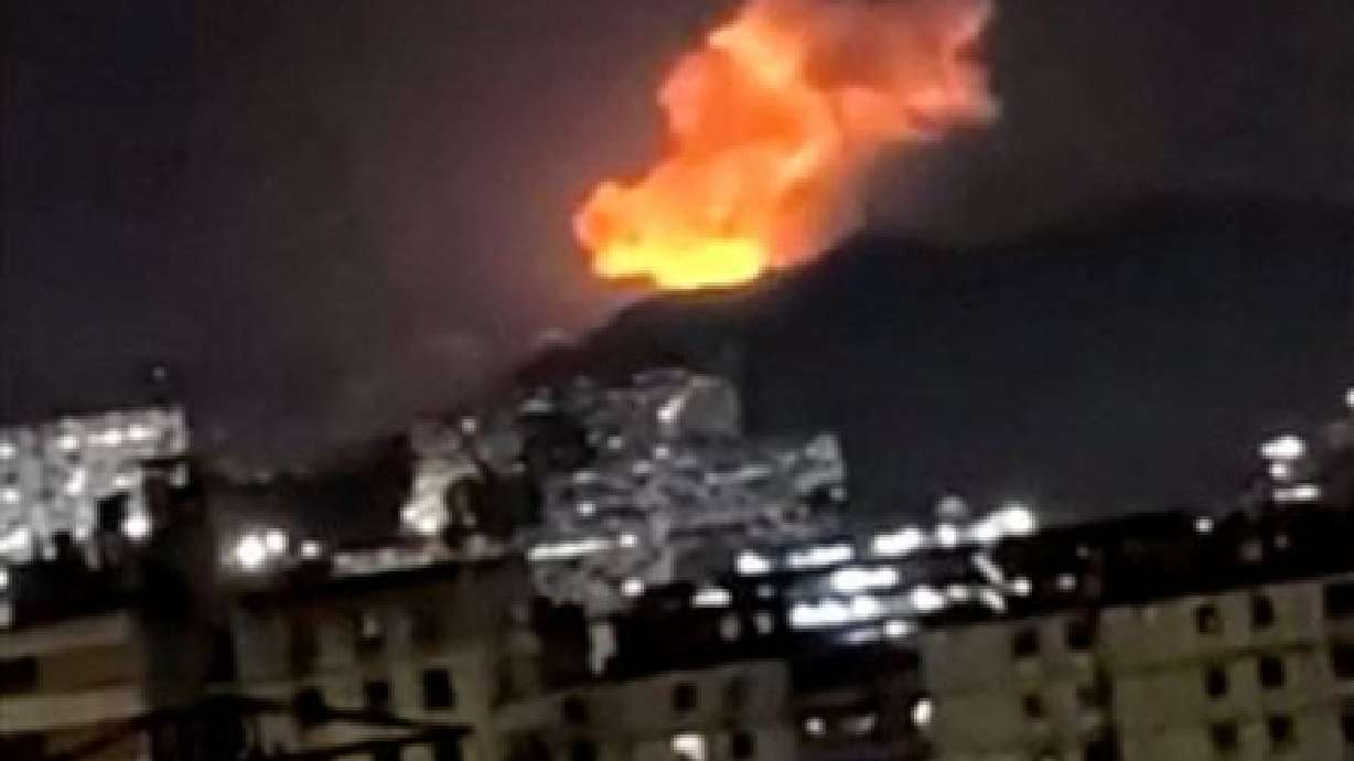 A column of smoke rises during multiple explosions in the early hours of the morning, in Caracas, V...