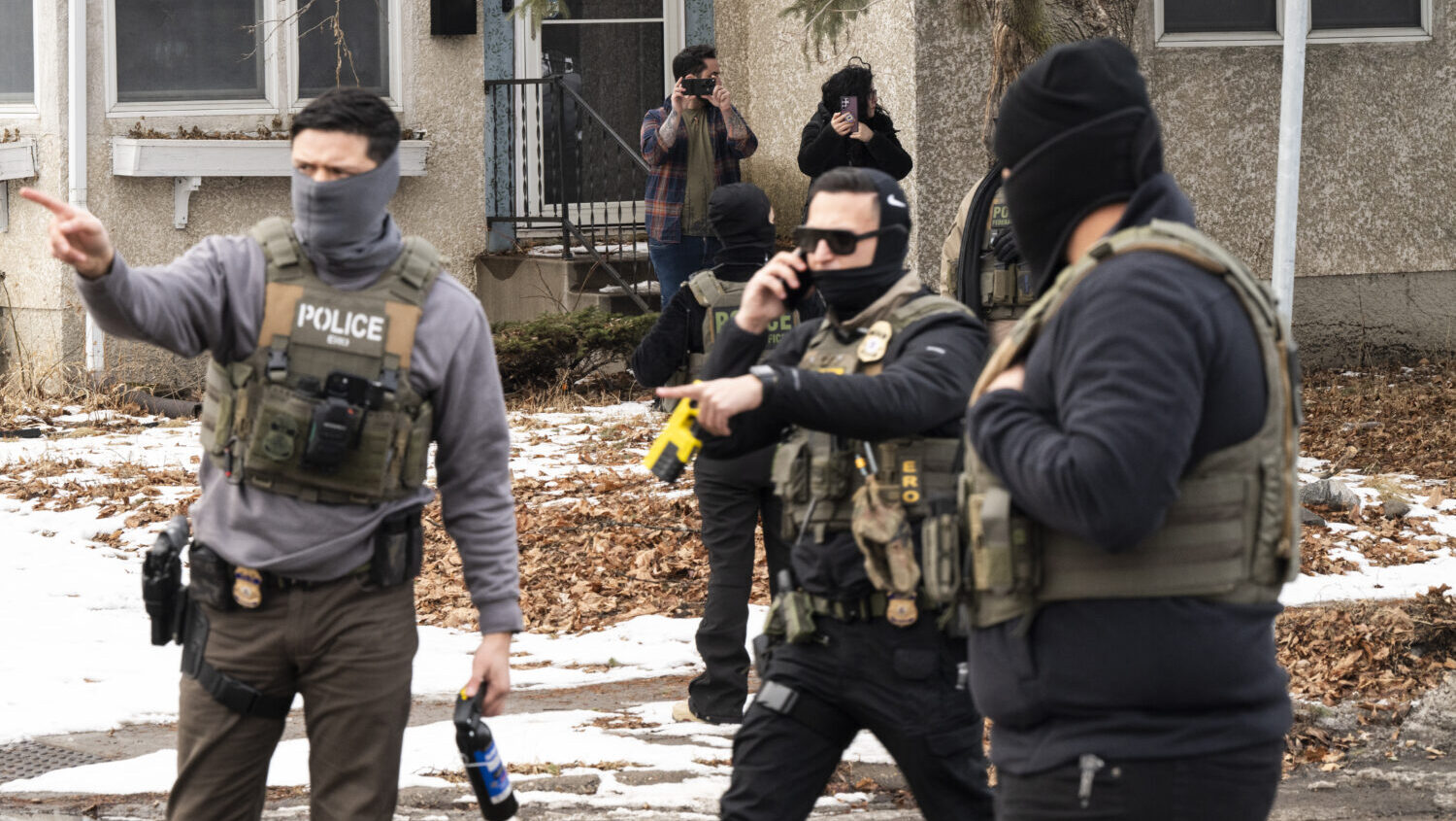 Observers film ICE agents as they hold a perimeter after one of their vehicles got a flat tire on P...