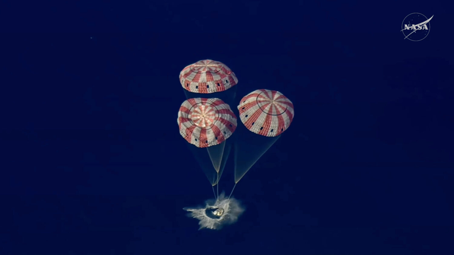 In this image from video provided by NASA, the Artemis II Orion capsule splashes down in the Pacifi...