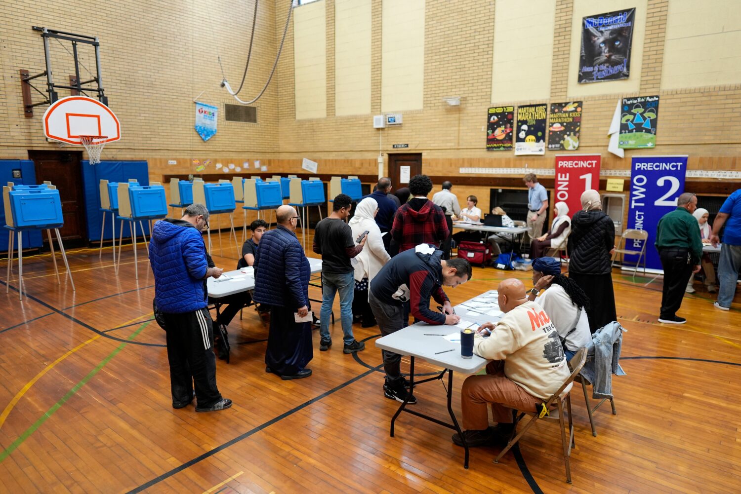 FILE - Voters wait to receive their ballots at a polling place at McDonald Elementary School, Nov. ...