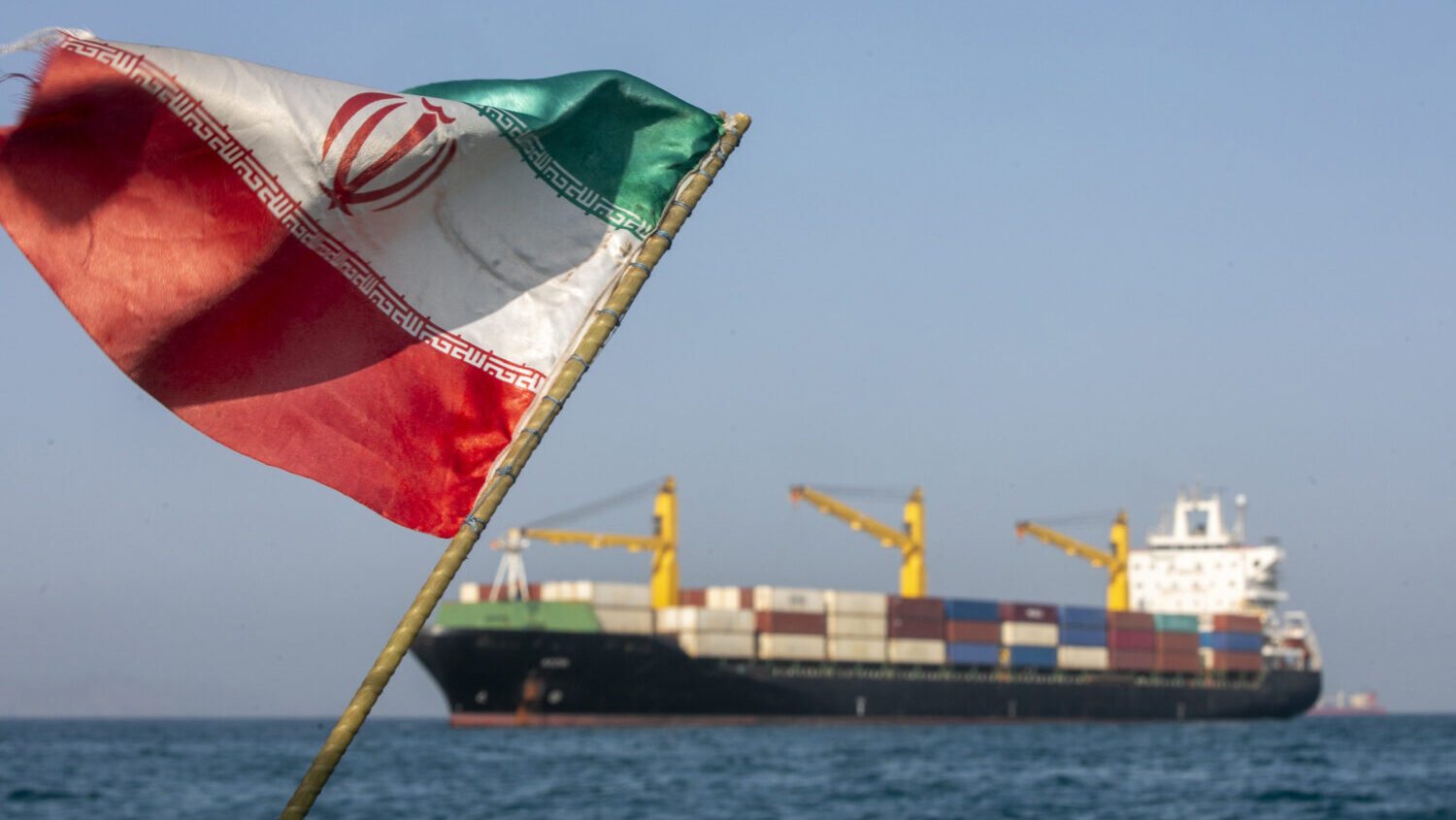 FILE: An Iranian flag flutters in the wind as ships remain anchored on May 16, 2026 in the Strait o...