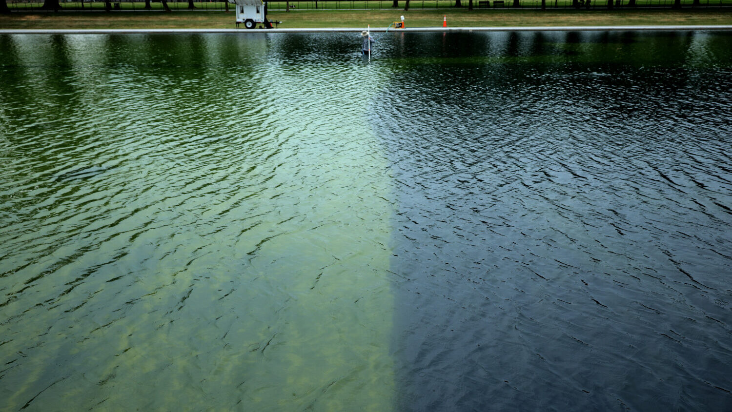 National Park Service employees and contractors use vacuums to remove green algae from the bottom of the Lincoln Memorial Reflecting Pool on June 18, 2026 in Washington, DC. The NPS is working to control and remove the algae bloom that has turned the pool green following the Trump Administration's recent $14 million repair, resealing and painting project. (Chip Somodevilla, Getty Images)
