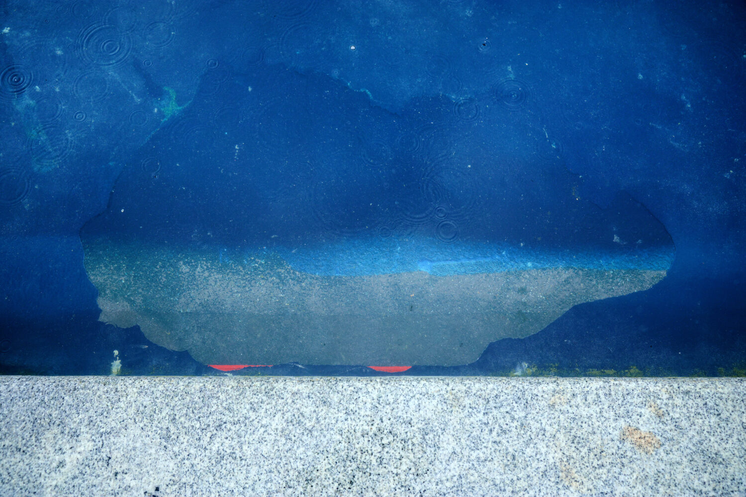 A large area where sealant or paint has peeled up to reveal the concrete bottom of the Lincoln Memorial Reflecting Pool is seen on the south side of the basin on the National Mall on June 23, 2026 in Washington, DC. U.S. President Donald Trump said that another round of repairs to the iconic basin will begin immediately after peeling paint and other issues were seen following the completion of its recent $14 million no-bid restoration project. (Chip Somodevilla, Getty Images)
