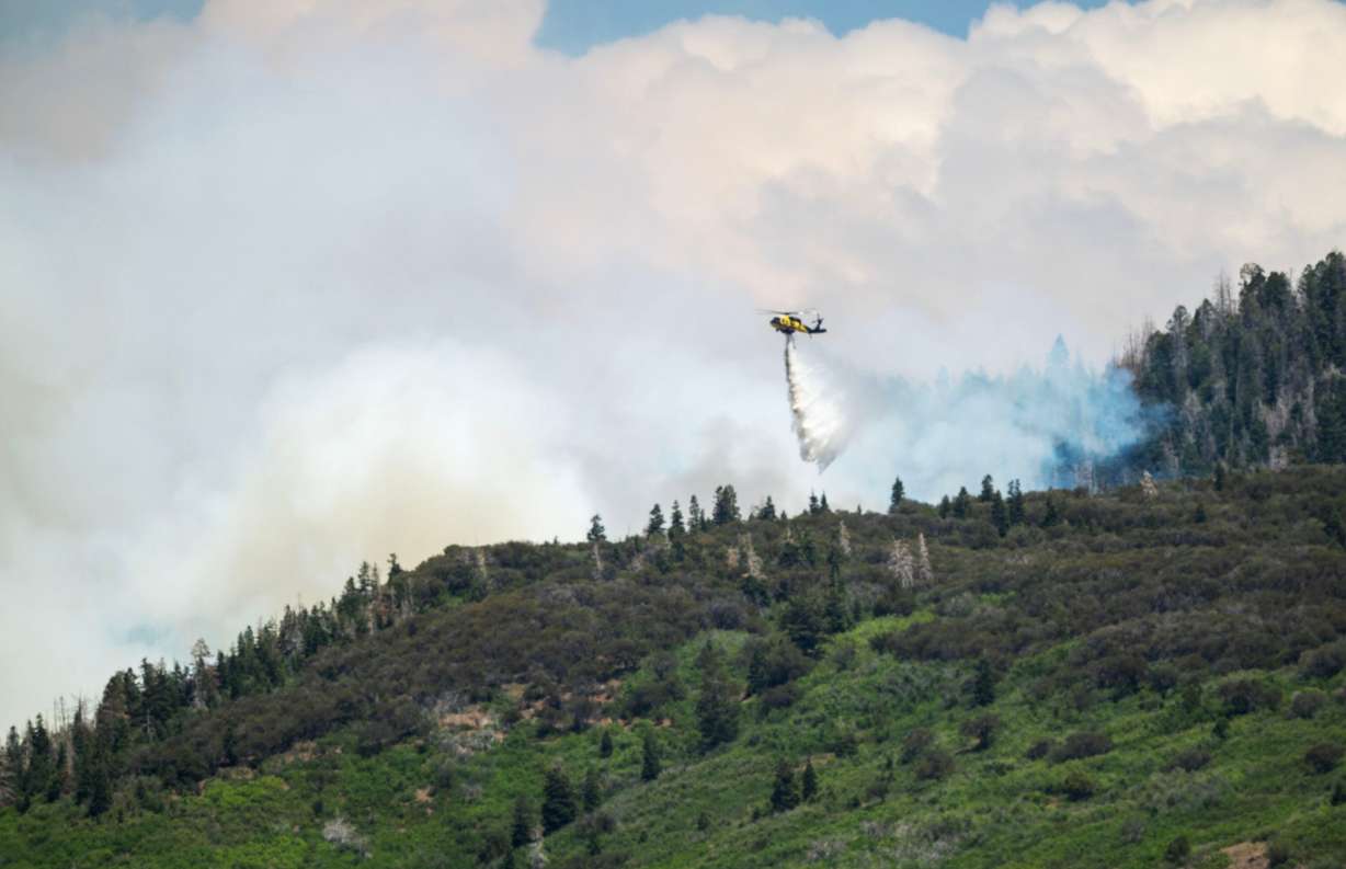 A helicopter drops water on the Cottonwood Fire that continues to burn east of the town of Beaver on Tuesday. The fire has torched more than 150 structures so far. (Photo: Scott G Winterton, Deseret News)