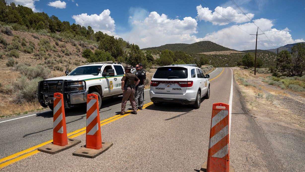 Rangers and Highway Patrol Troopers talk at a road block on state Road 153 toward Beaver Canyon as the Cottonwood Fire continues to burn east of Beaver on Tuesday. Utahns are coming together to support those affected by this summer's fires. (Photo: Scott G Winterton, Deseret News)