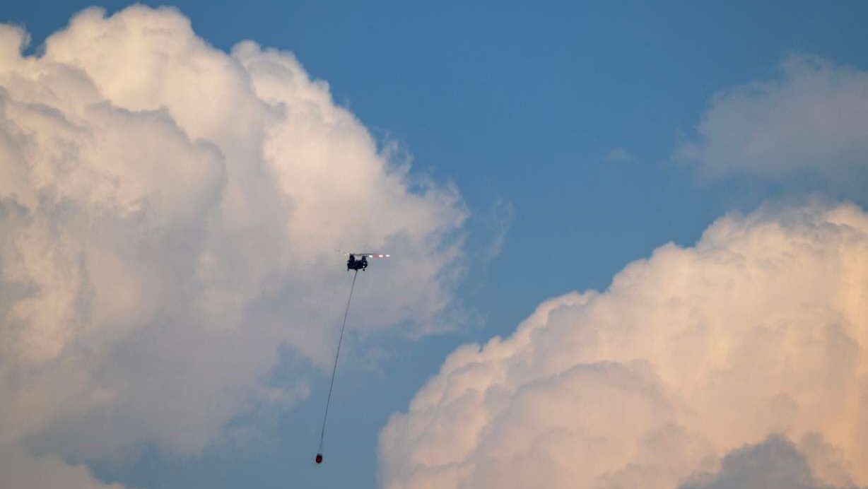 A twin rotor helicopter flies over the fire headed for water on Tuesday. The Cottonwood Fire continues to burn east of the town of Beaver. (Photo: Scott G Winterton, Deseret News)