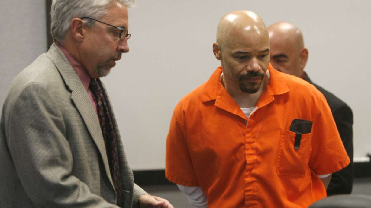 Defense lawyer Mark Moffat, left, clears a spot at the table for death row inmate Douglas Stewart C...