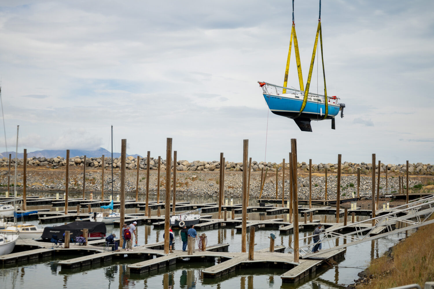 The Great Salt Lake State Park removes 1 of 23 boats from the Great Salt Lake Marina, due to critically low lake levels that make sailing difficult at the Great Salt Lake State Park and Marina in Magna on Saturday, May 30, 2026. Known informally as “Crane Day,” the operation involves cranes lifting sailboats with deep keels out of the marina and placing them into dry storage because water levels are too low for safe navigation. Similar crane operations were required during periods of low water in 2015 and 2021. (Tess Crowley, Deseret News)