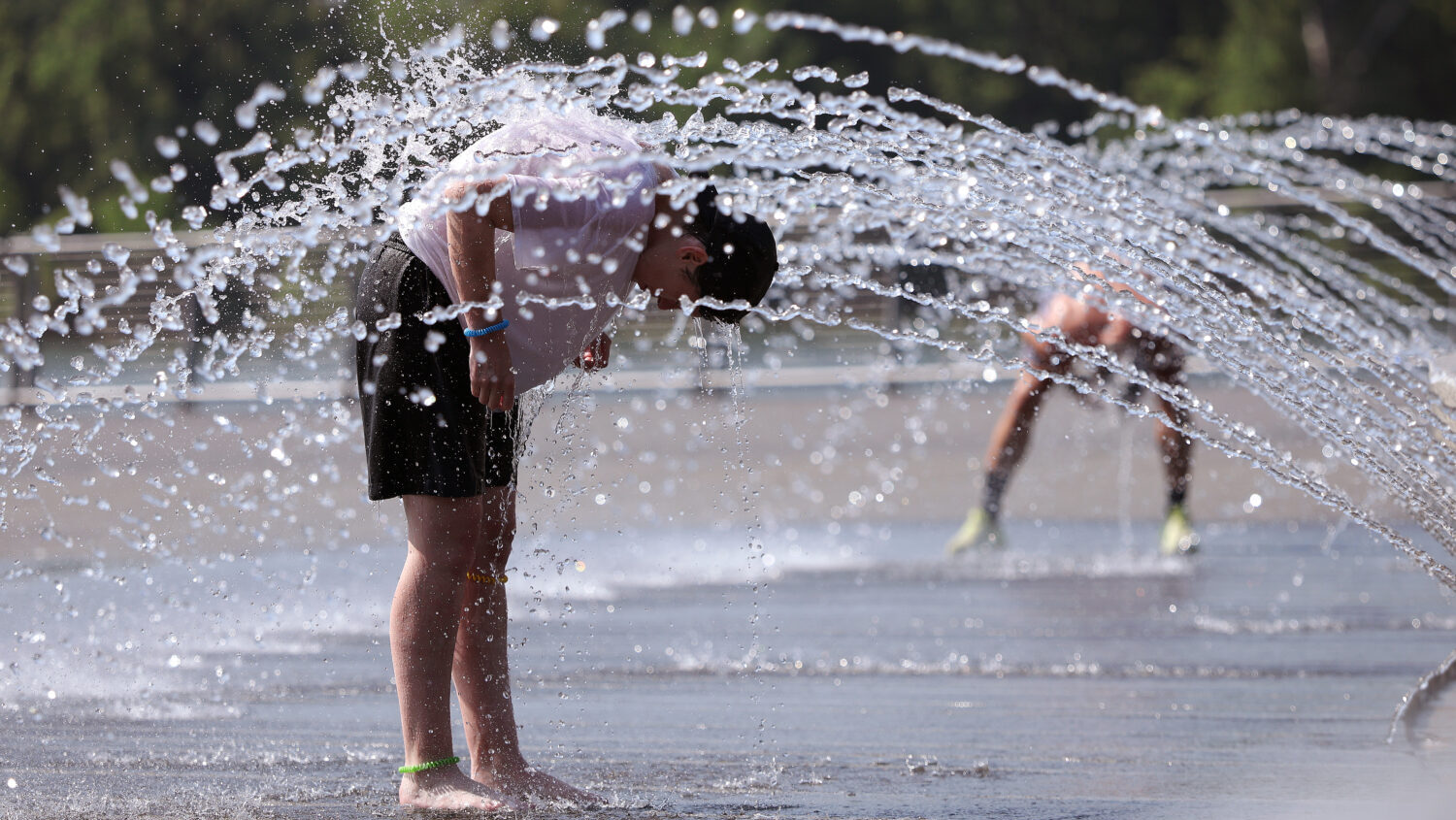 People cool off in a fountain at the Georgetown Waterfront Park on July 02, 2026 in Washington, DC. Temperatures in the nation's capital are expected to top 100 degrees as a heat wave stretching from the Midwest to the East Coast impacts up to 90 million Americans. (Kevin Dietsch, Getty Images)