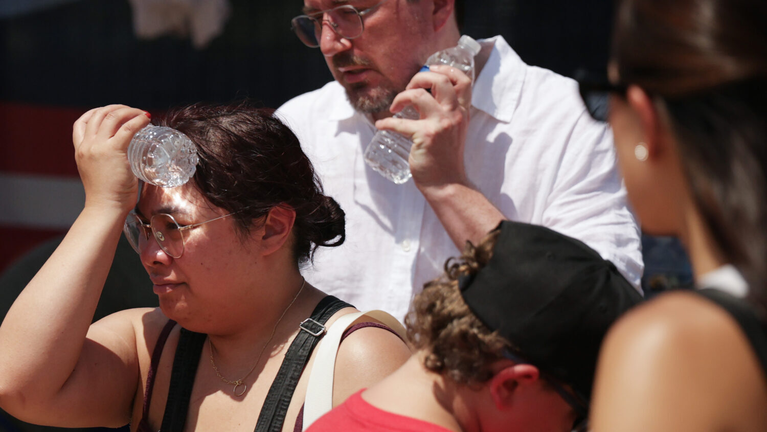 People cool themselves with an ice-cold water bottle from a water station during the Great American...