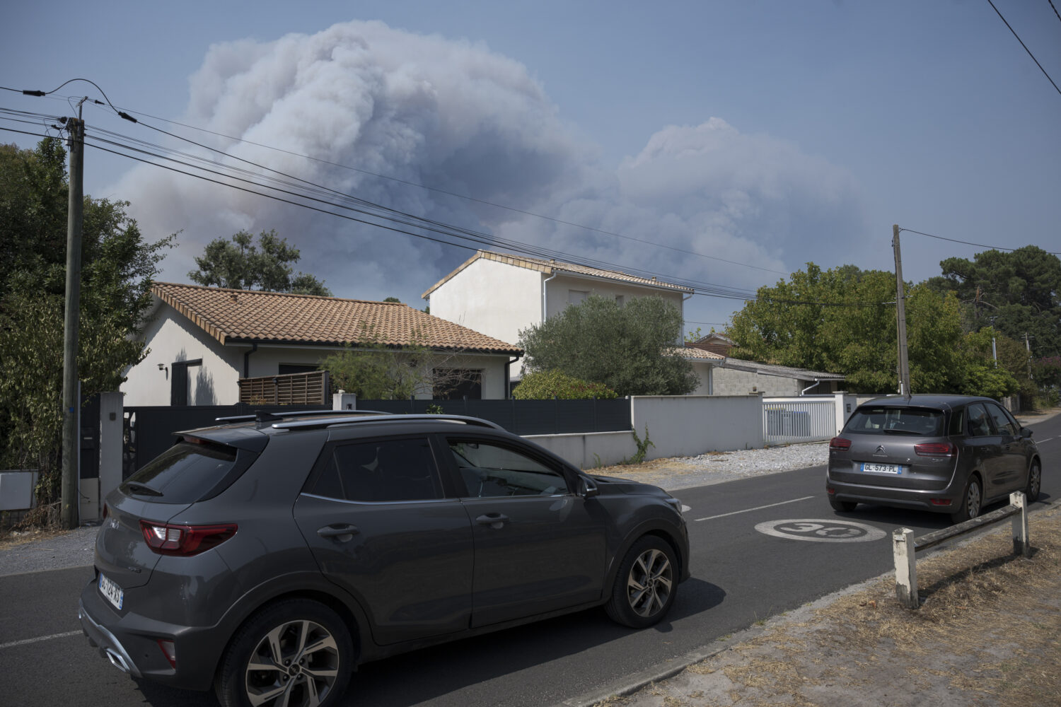 People leave their homes after wildfires in the area forced thousands of tourists to evacuate on July 24, 2026 in Arcachon, France. (Gari Garaialde, Getty Images)