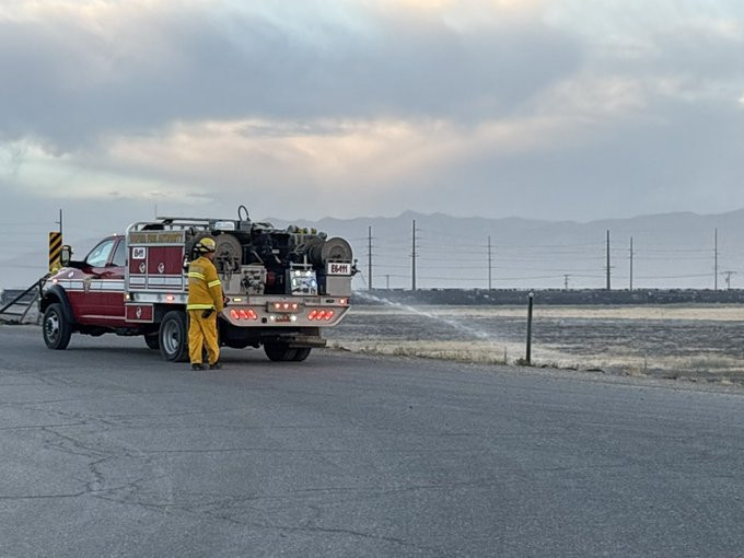 A Utah Fire Authority firefighter sprays water on a grass fire near I-80 and 7200 West on Wednesday, July 8, 2026. (Photo: Salt Lake City Fire Department)