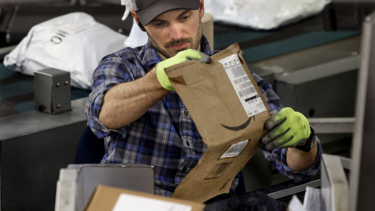 Bryan Freeborn works at one of the package sorting machines at the United States Postal Service Pri...