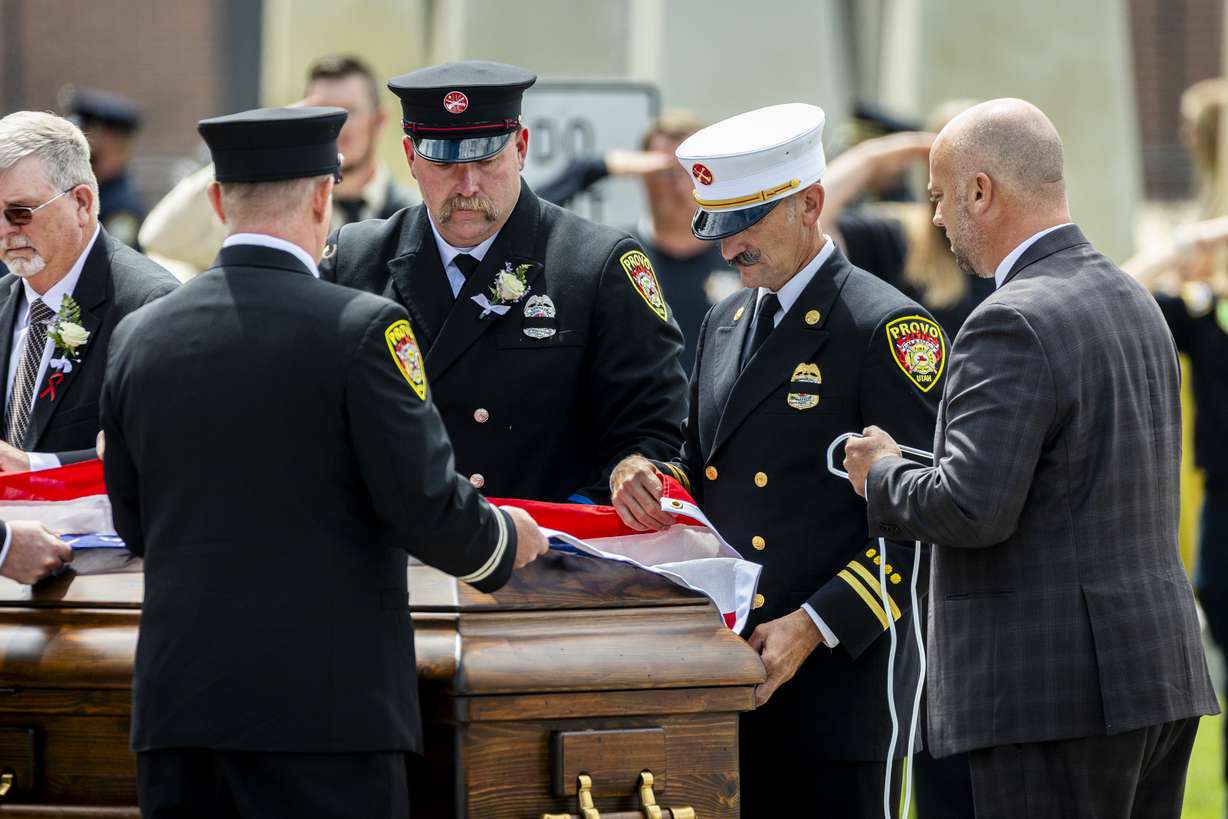 Members of the Provo Fire Department drape an American flag on the casket of Provo Fire Capt. Spencer Long after his family’s funeral at the UCCU Center in Orem on Wednesday. (Photo: Isaac Hale, Deseret News)