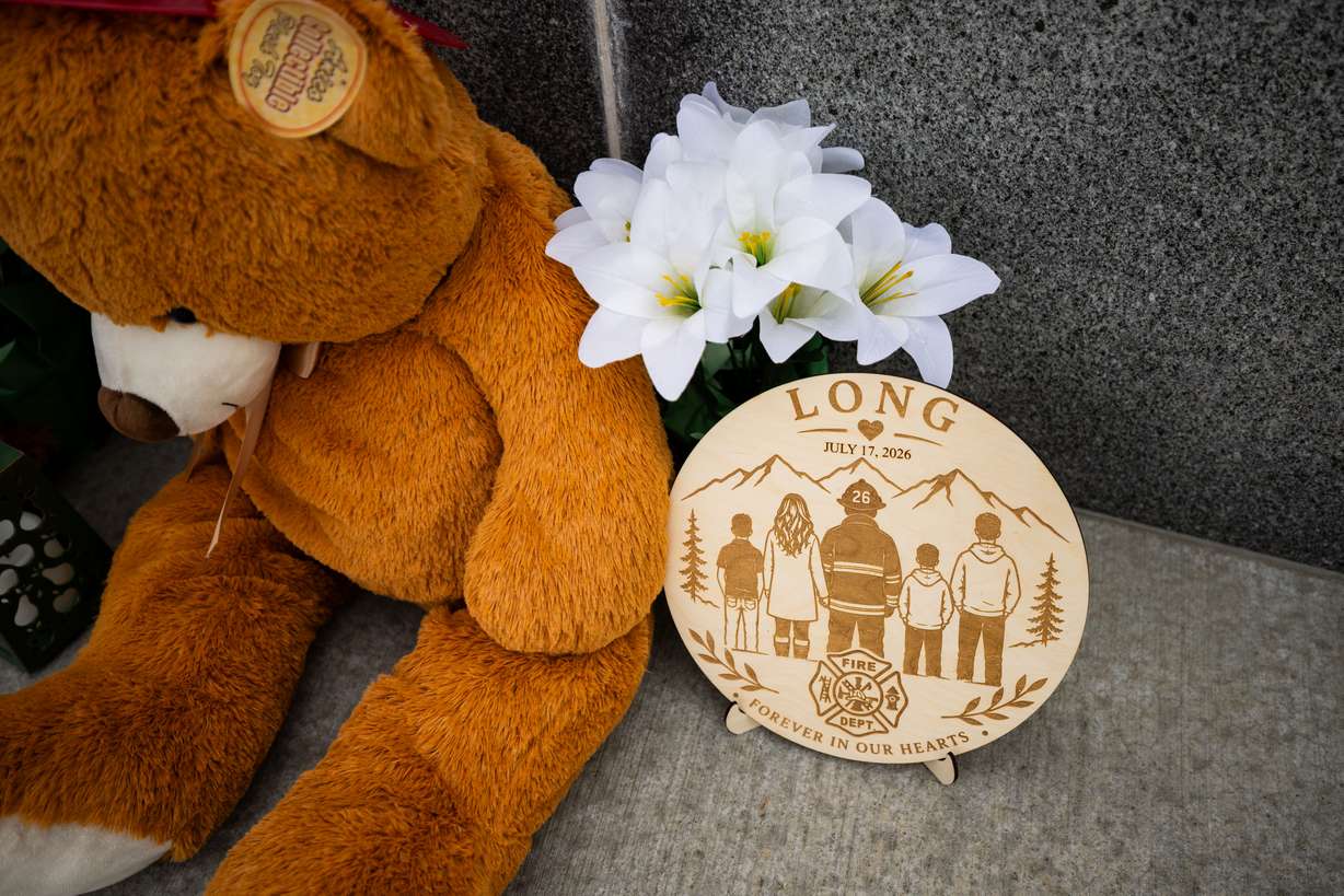 A memorial with flowers, stuffed animals and photos for Provo Fire Capt. Spencer Long and four members of his family who were killed in a flash flood during a weekend camping and hiking trip in Wayne County, outside of City Hall in Provo on July 22. (Photo: Tess Crowley, Deseret News)