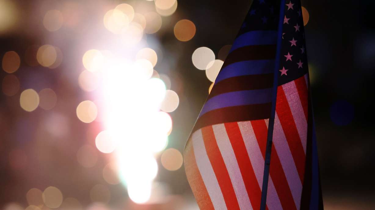 A small American flag is illuminated by fireworks on July 4, 2022. Explore where your family can at...