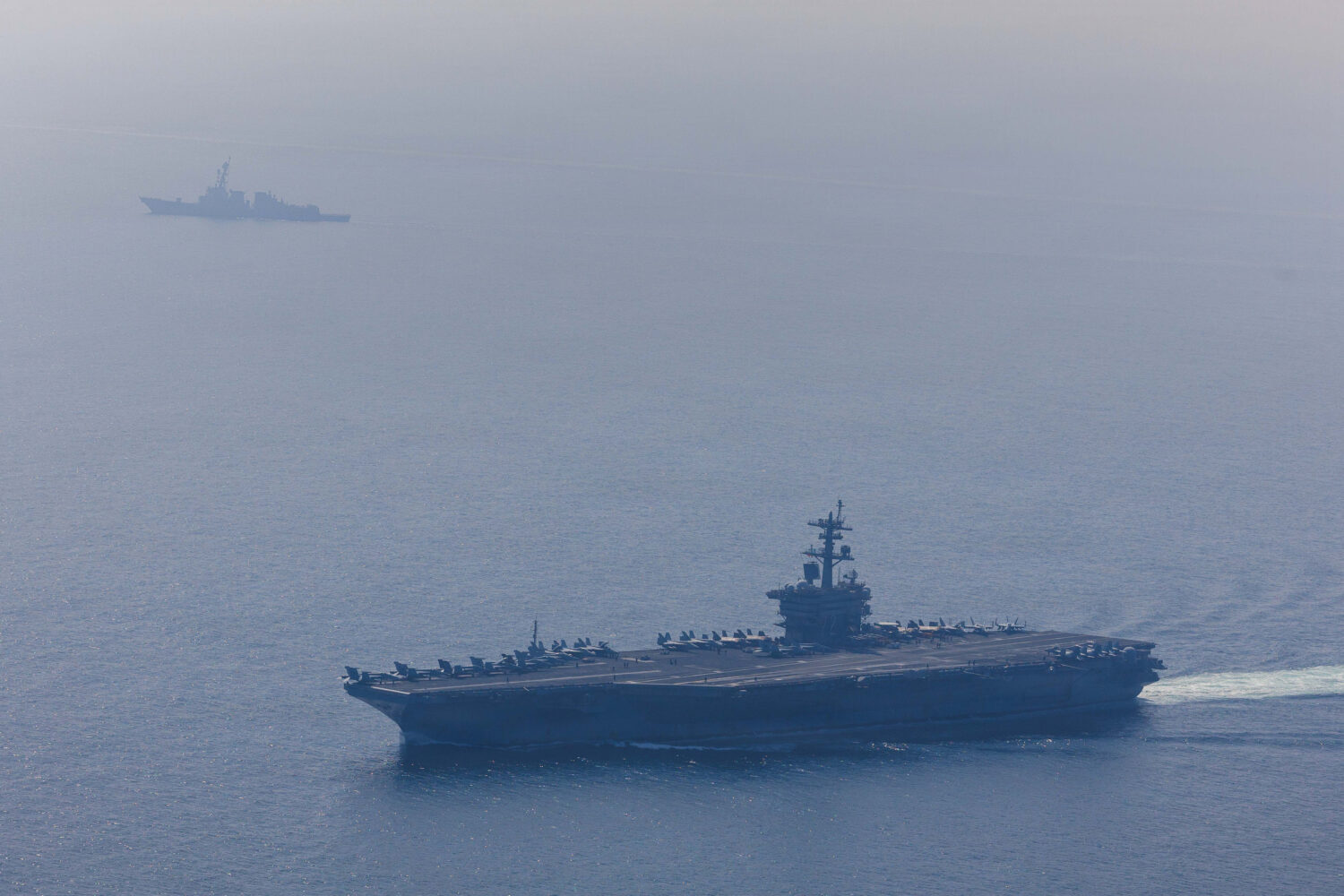 FILE: In this handout photo obtained from the U.S. Defence Department, Nimitz-class aircraft carrier USS Abraham Lincoln (CVN 72) and Arleigh Burke-class guided-missile destroyer USS Frank E. Petersen Jr. (DDG 121) sail in the Arabian Sea, Feb. 6, 2026. (Handout photo by Mass Communication Specialist 1st Class Jesse Monford, U.S. Navy via Getty Images)