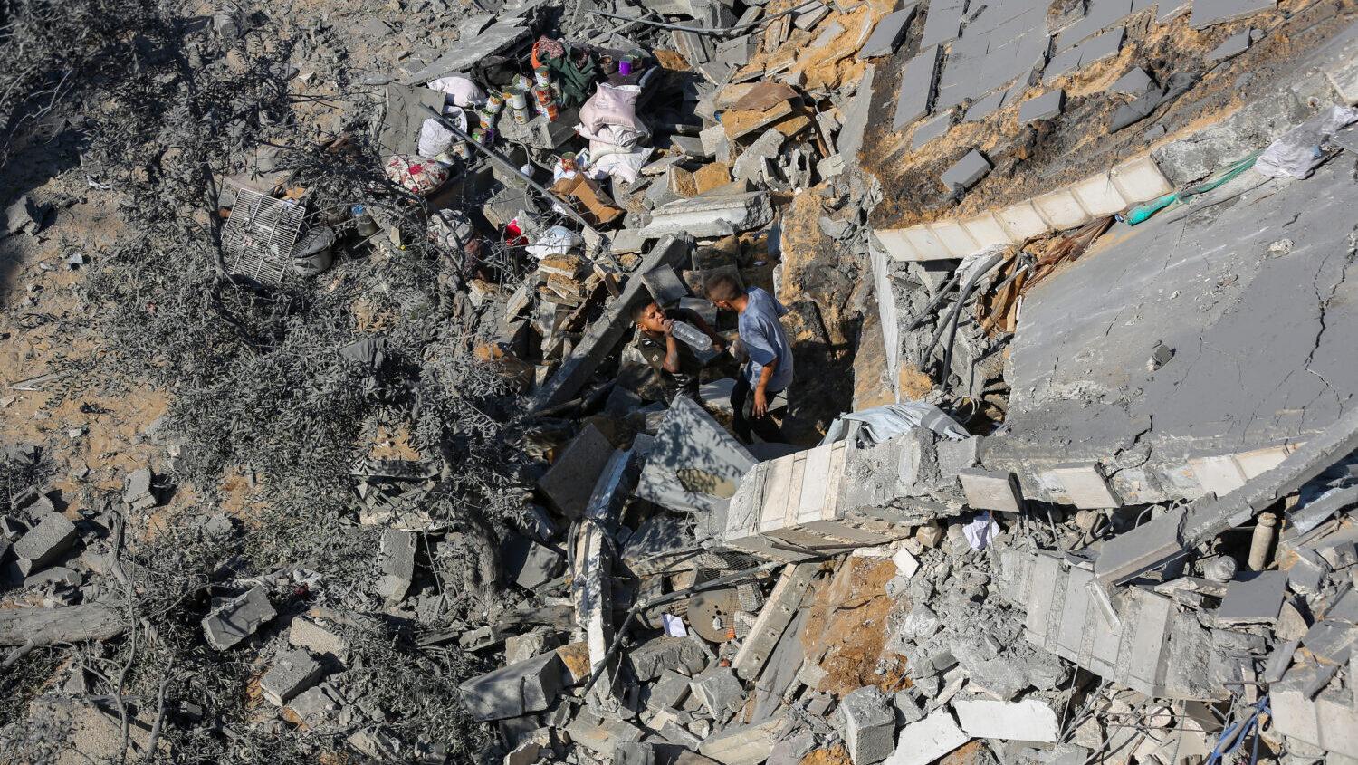 Residents inspect the damage caused by Israeli airstrikes on residential buildings in the Safatawi ...