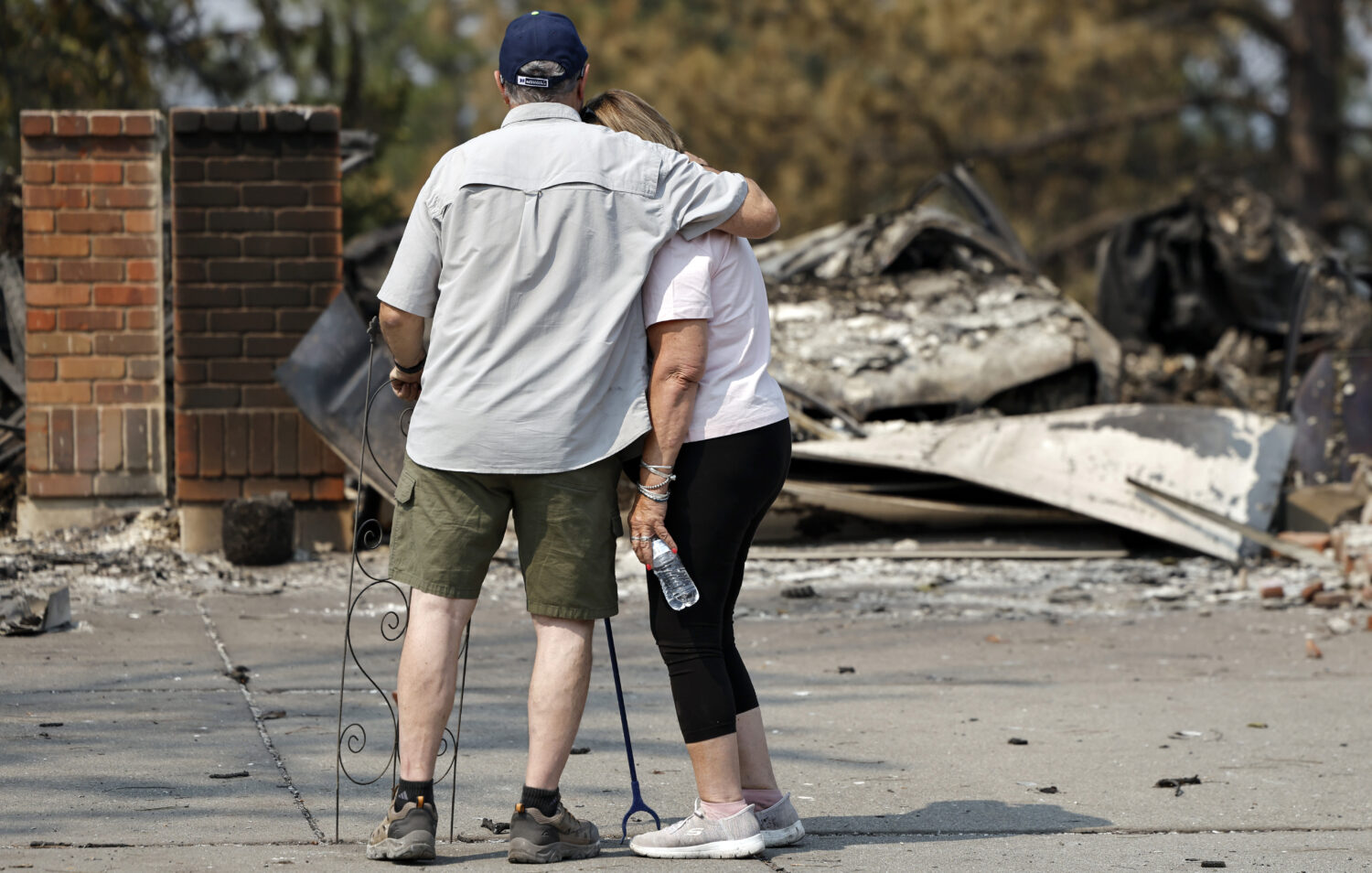 Jim Zimmer (L) hugs his wife in front of the remains of their home which was destroyed in the Old T...