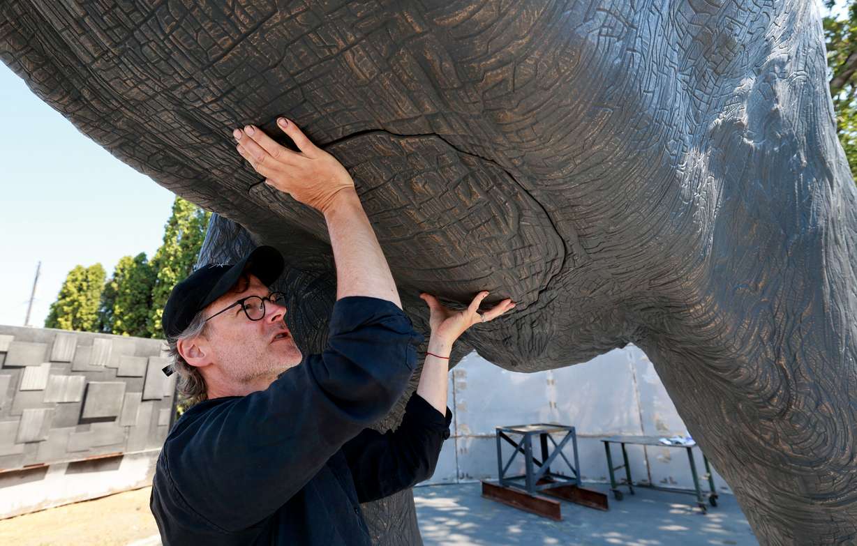Matthew Gray Palmer shows where he will weld the final piece of an elephant's belly onto Yumi, a roughly 18,000-pound bronze elephant Palmer has been sculpting and building for seven years, at Metal Art Foundry in Lehi on Thursday. (Photo: Kristin Murphy, Deseret News)