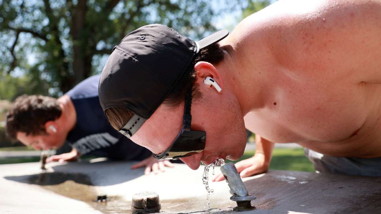 Nick Sylvester takes a break from running to drink water at Liberty Park during a heat wave in Salt...