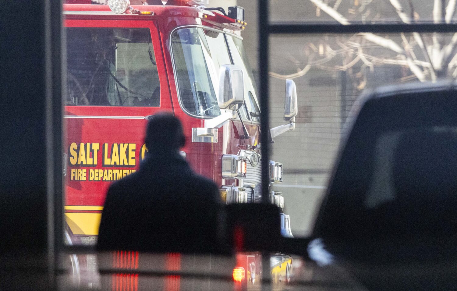 A resident watches from their parking garage while Salt Lake City Fire Department crews put out a four-alarm commercial fire at an abandoned section of a large building located at 1030 South and 200 West in Salt Lake City on Thursday, Dec. 19, 2024. (Brice Tucker, Deseret News)